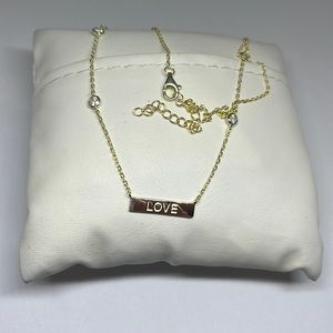 White cz 18kyellow gold/ss “LOVE” necklace .72 ctw., pendant never worn